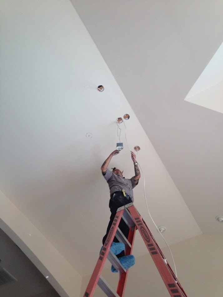 Master electrician installing chandeliers
