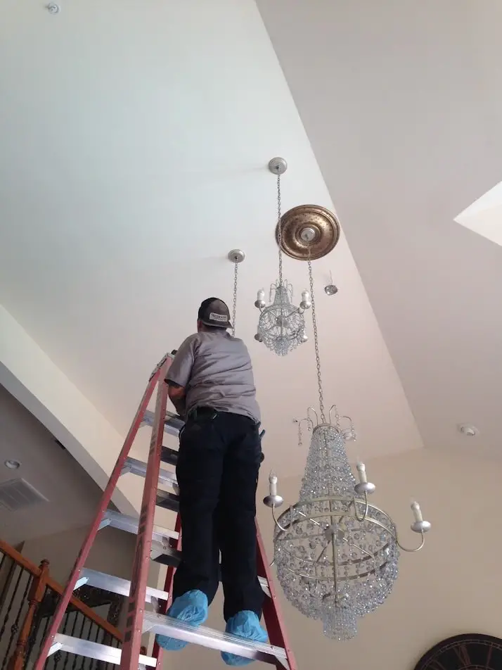 Master electrician installing chandeliers